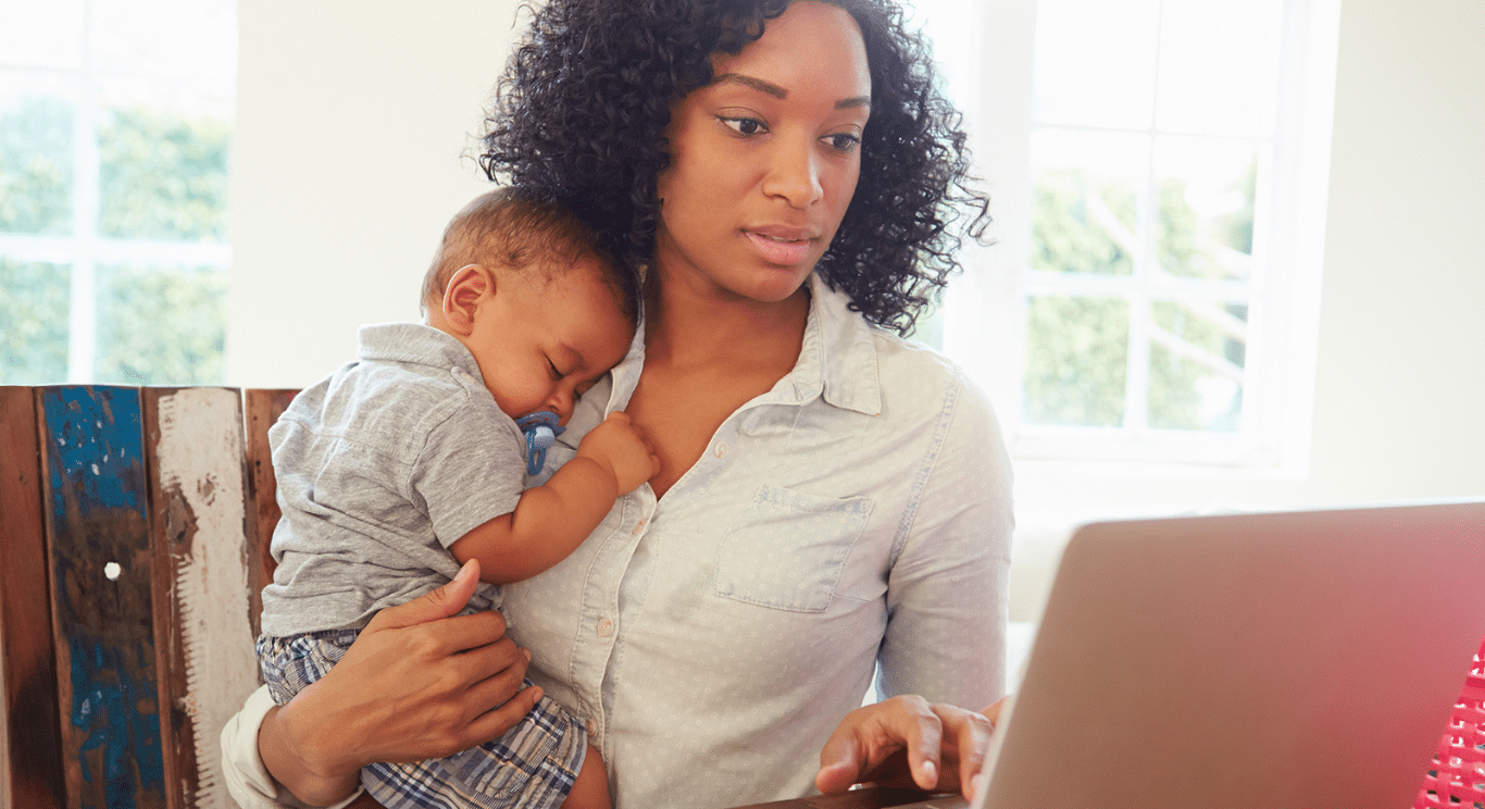 Woman holding baby while working